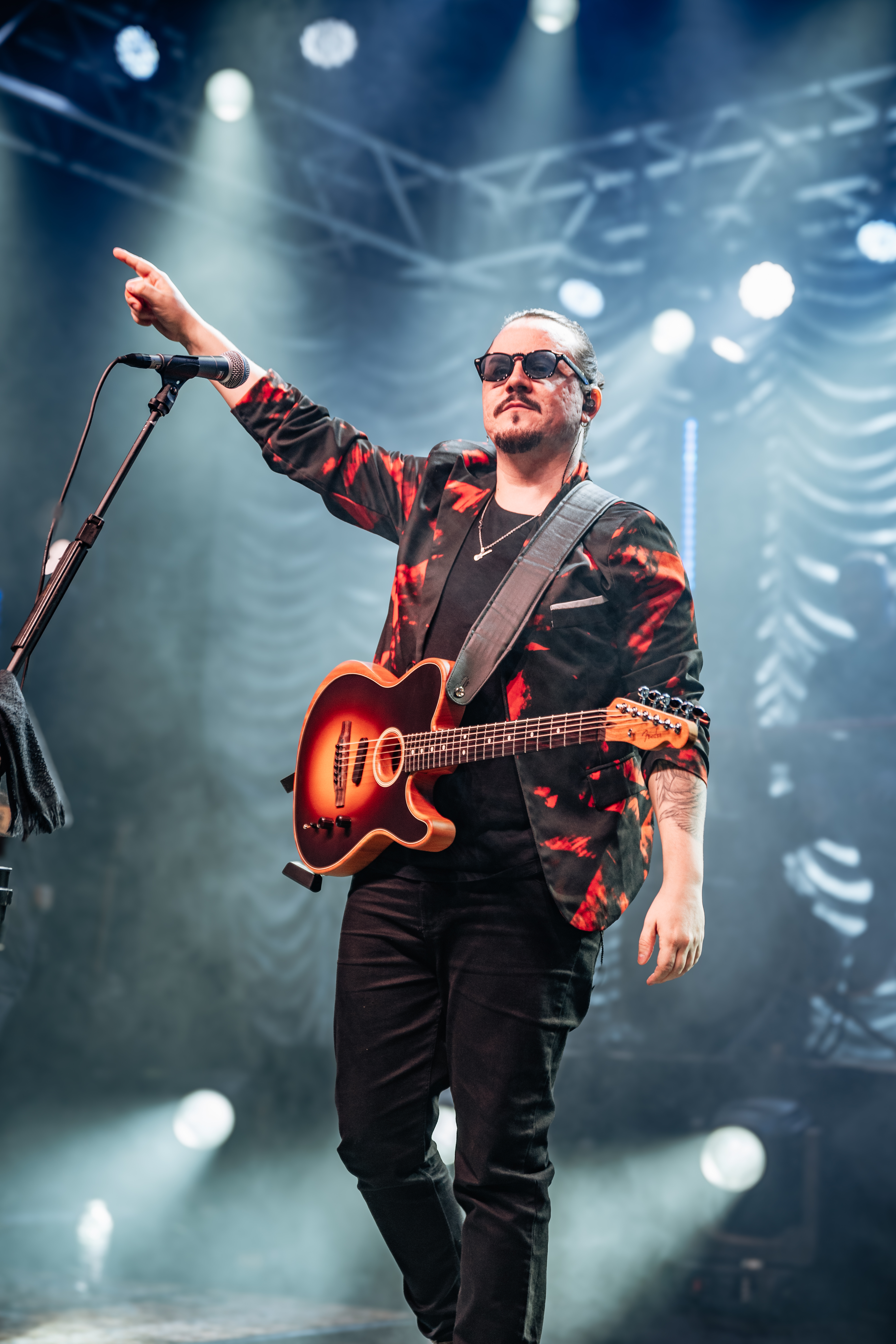 Dino com guitarra apontando para o público