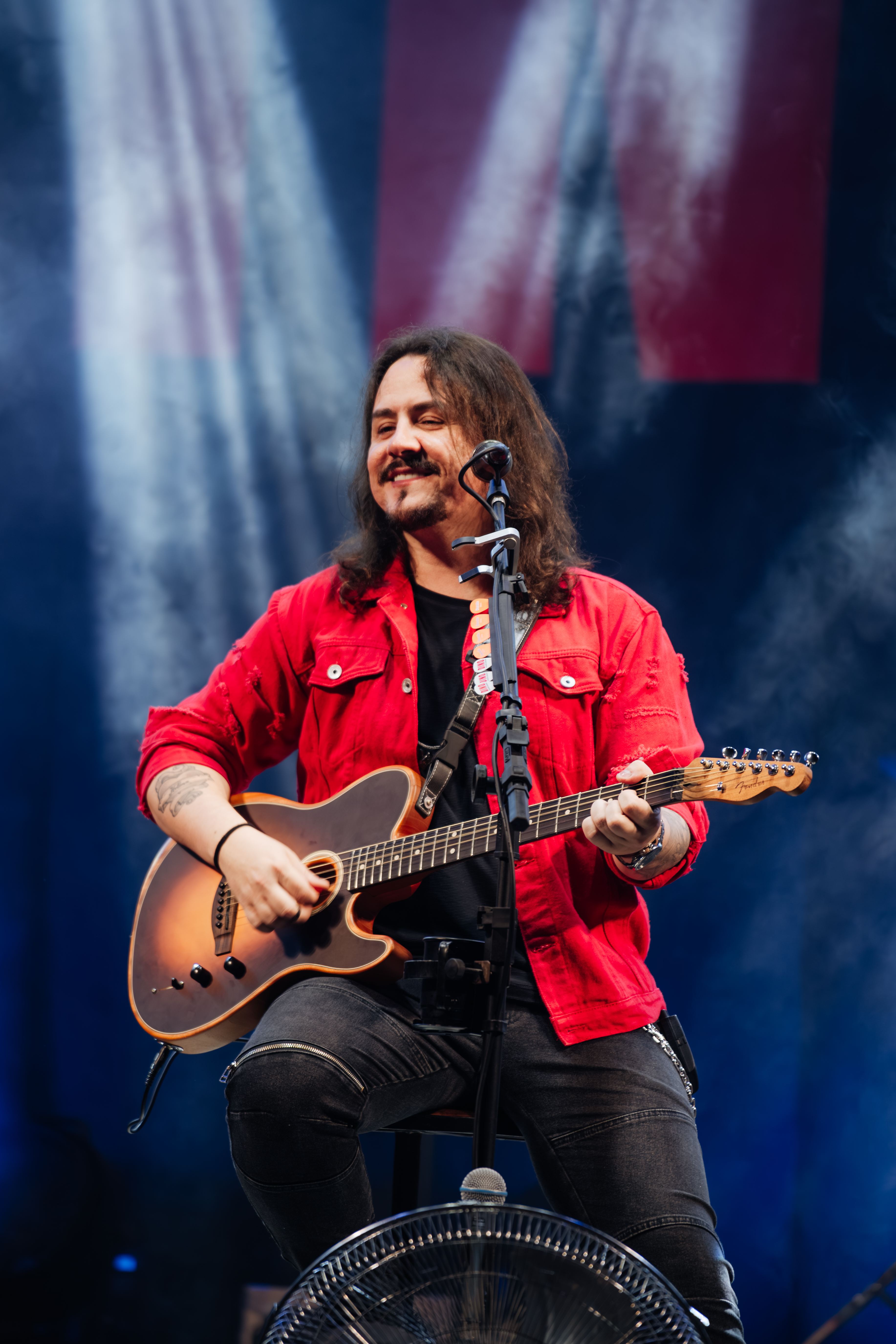 Dino tocando guitarra de camisa vermelha