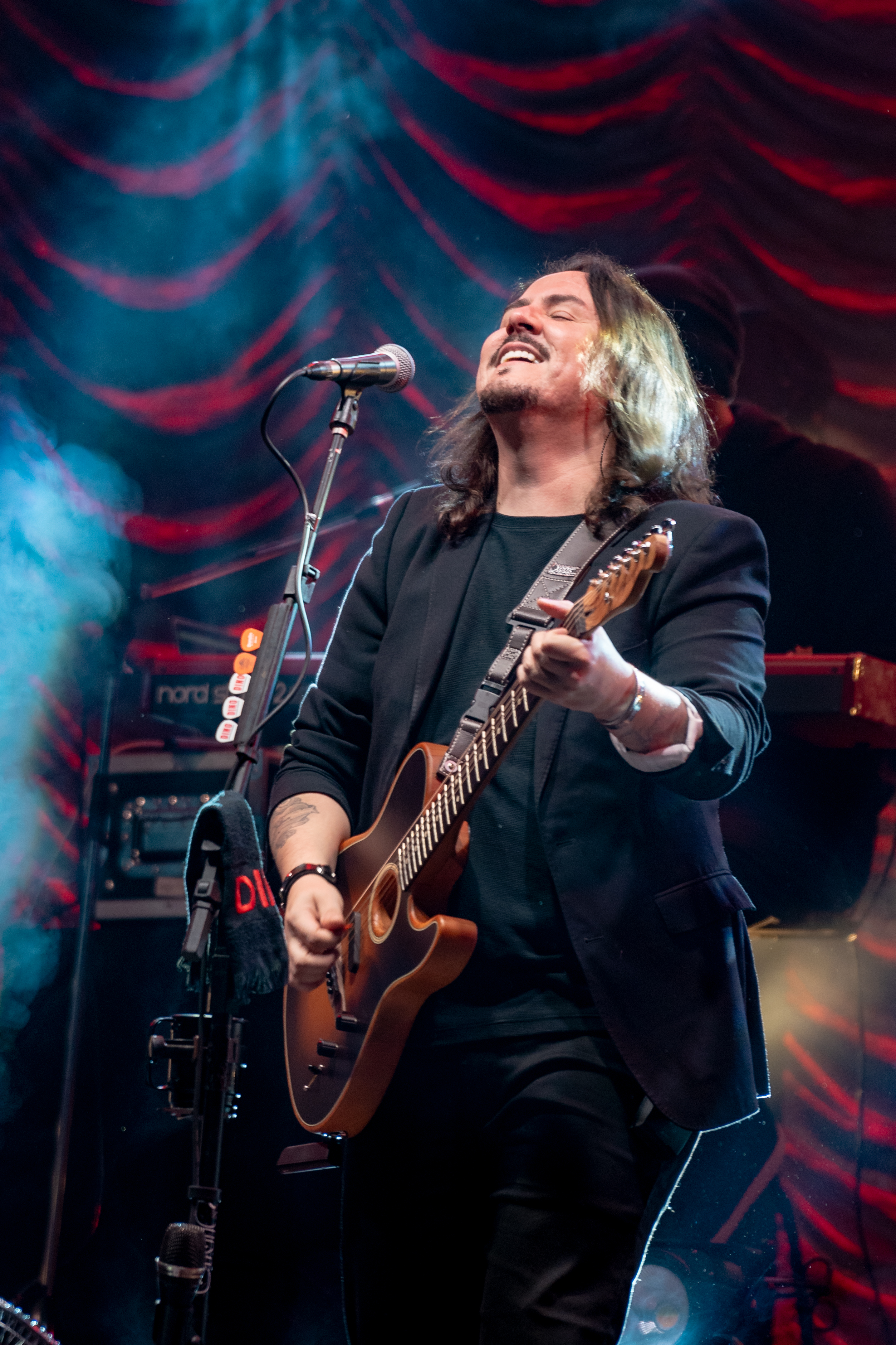 Dino Fonseca sorrindo tocando guitarra